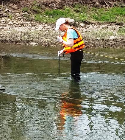 Stephanie Janosy collects a water quality sample using a DH-81 at Tiffin River near Evansport, Ohio. (Credit: Donna Runkle)