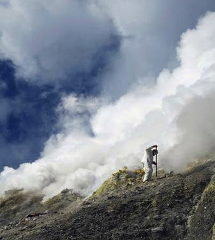 Tobias Fischer and other gas chemists conducted some of the most dangerous work during the expedition to obtain samples of toxic gases from the volcano summits. Fischer is sampling 300-degrees-Celsius hot gas vents at the summit of Gareloi Volcano in the Western Aleutians. This volcano has never before been sampled for gases. (Credit: Taryn Lopez / University of Alaska)