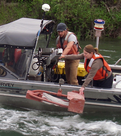 Hydrologic technicians retrieve a bedload sample from the Kootenai River near Bonners Ferry, Idaho. The U.S. Geological Survey compared the results of bedload and suspended sediment sampling with data collected from acoustic devices submerged in the river. (Credit: U.S. Geological Survey)