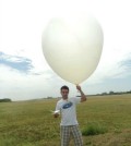 Angel Adames with a research weather balloon and box to track temperatures and more at the DYNAMO field campaign in the Maldive Islands. (Credit: University of Washington)