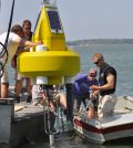 Dr. Justin Chaffin prepares to deploy a data buoy in Lake Erie. (Credit: Ohio Sea Grant)