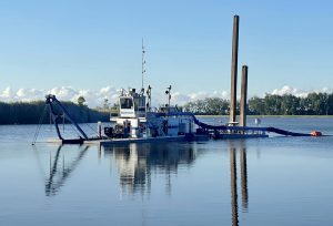A blue Sevenson dredger on the water