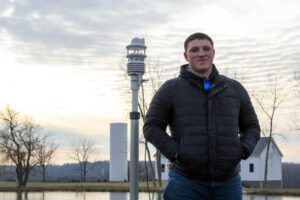 Applications Scientist, Joe Davidson, next to the Lufft WS800 after deploying the sensor for new product testing