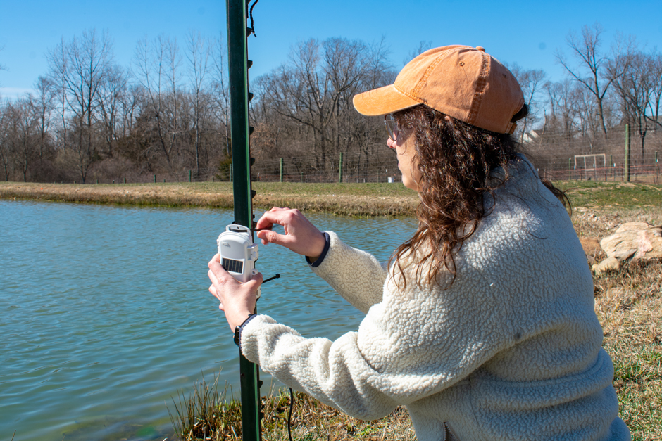 Environmental Scientist Katelyn Kubasky secures the Onset soil moisture probe sensor mote at the field station