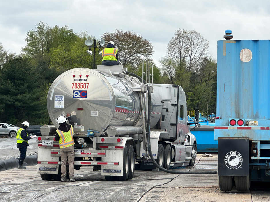 Liquid waste is loaded, labeled, and logged within a secondary containment area.