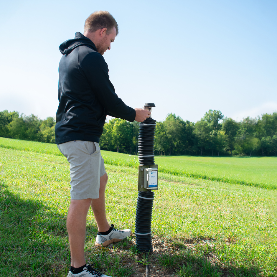 Application Engineer Justin Walters secures Van Essen external antenna on a mast pole at the field station. 