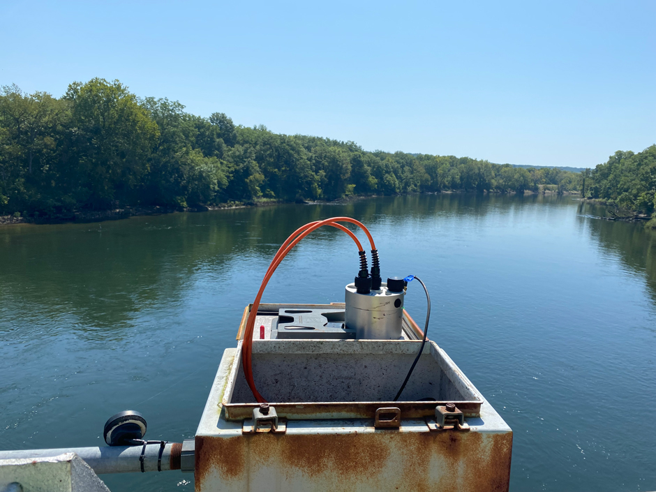 A Nexsens datalogger sits on the open lid of its metal housing attached to Langley Bridge overlooking the Neosho River downstream of Pensacola Dam in Oklahoma.