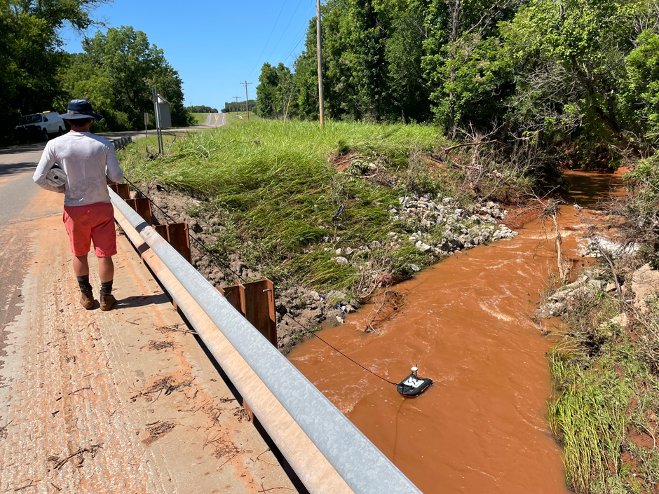 A seasonal OWRB staff member collects a stormwater discharge measurement using an ADCP at Upper Dave Blue Creek in Norman, Oklahoma. 