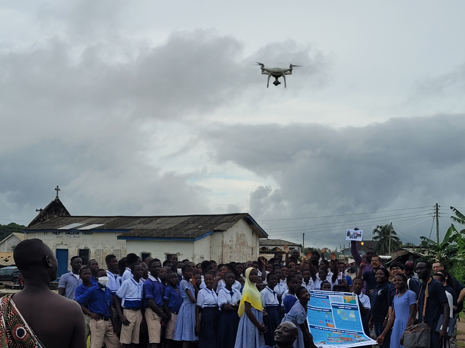 School children in Ghana watch a drone launched for surveys during a More than Maps citizen science workshop teaching them environmental monitoring skills.