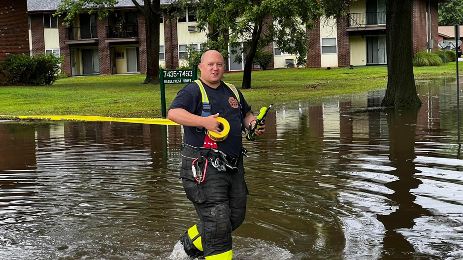 Battalion Chief Leichenauer of the Hazelwood FIre Department walks through flood waters as he cordons off an apartment complex affected by flooding from Coldwater Creek in 2022.