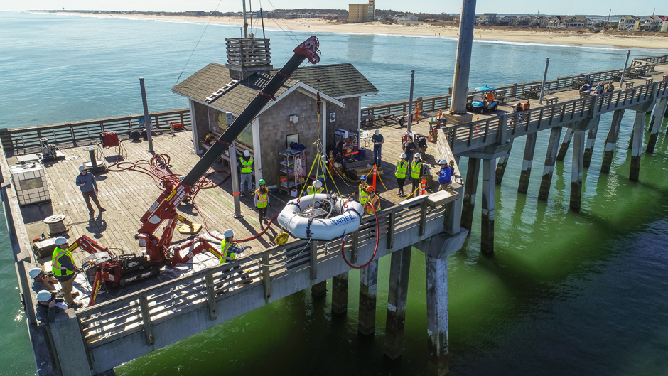 The HERO WEC deployment teams from NREL and the Coastal Studies Institute deploying the HERO WEC at Jennette’s Pier.