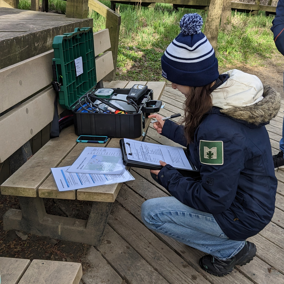 Metroparks Toledo staff recording water data from the Ottawa River at Wildwood Preserve.