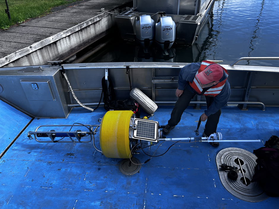 Research technician Jeffrey Neuse loads the Mawikwe Panther Buoy onto the Apostle Islands work boat.