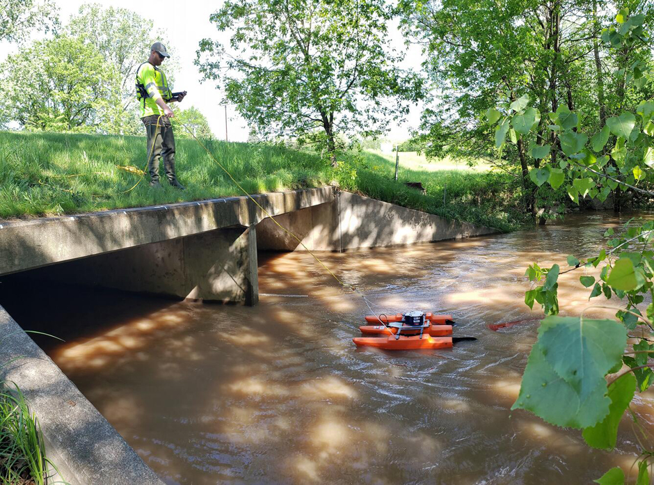 Hydrologic Technician Matthew Bach making a discharge measurement using an acoustic doppler current profiler (ADCP) at the Dutchman Creek near Ashwaubenon, WI.