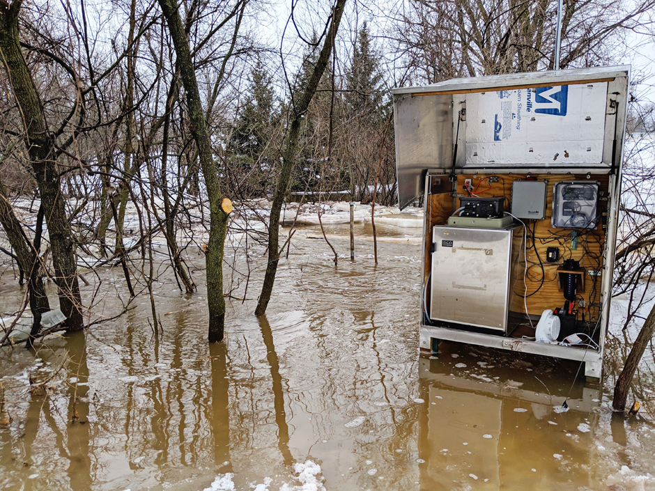 Stream gage enclosure at the Dutchman Creek near Ashwaubenon, WI during extreme flows during spring ice melt runoff.