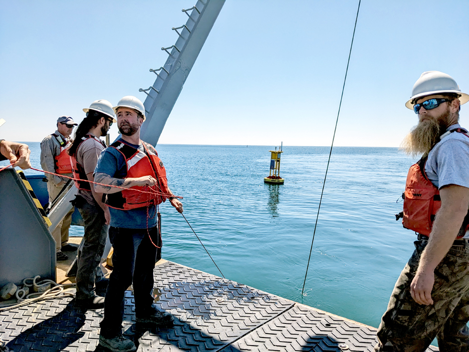 CORMP technicians, Chris LaClair and Doug Faircloth, work alongside RV Savannah crew members to deploy a new buoy and mooring offshore of Charleston, SC.