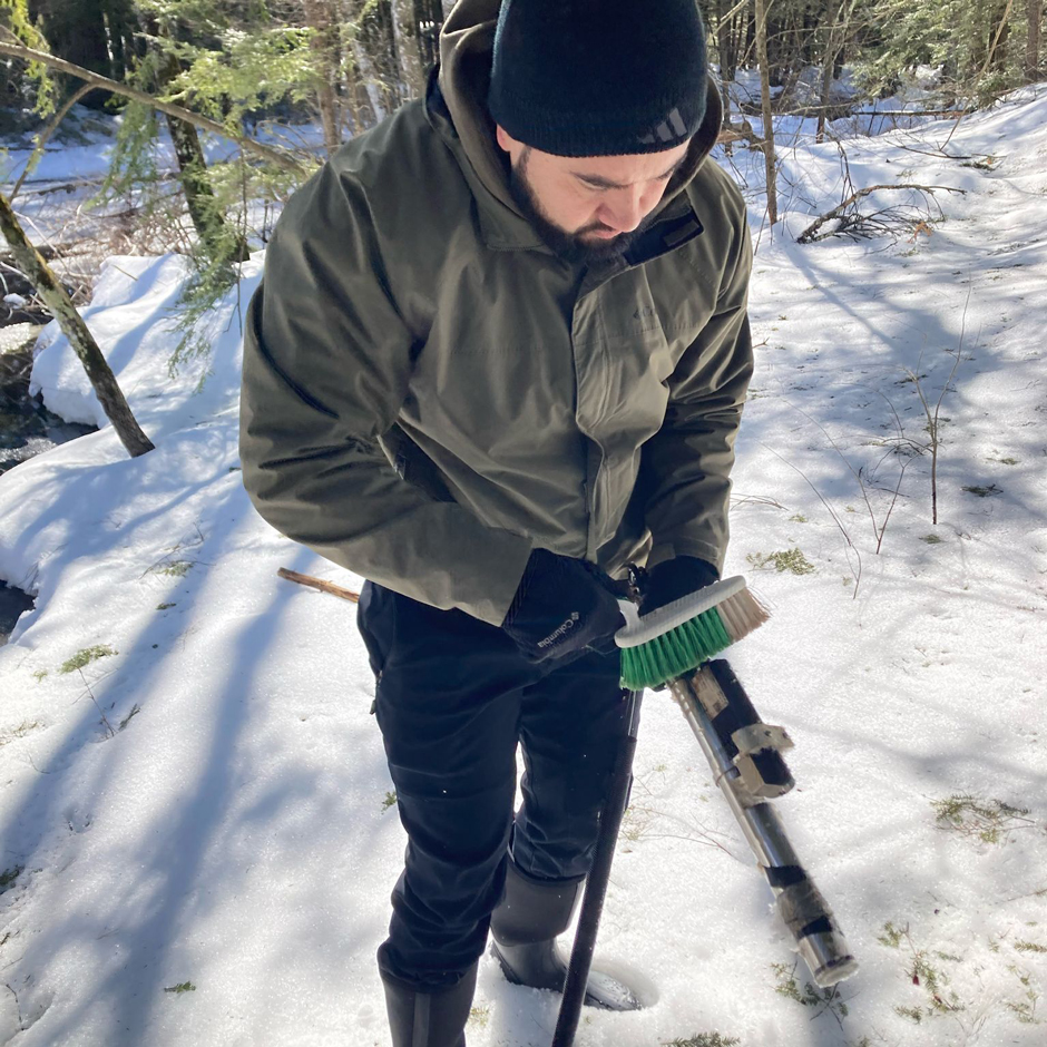 Post-doctoral researcher Dr. Juan Pesantez cleans a S:: CAN spectrolyser during the winter field season.