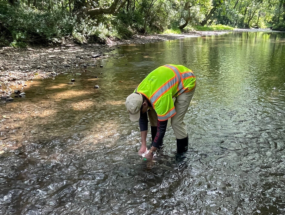Ohio EPA intern, Joel Steinbicker, collects a water sample from Rocky Fork Licking River near Hanover, OH for the 2025 Licking River watershed survey.
