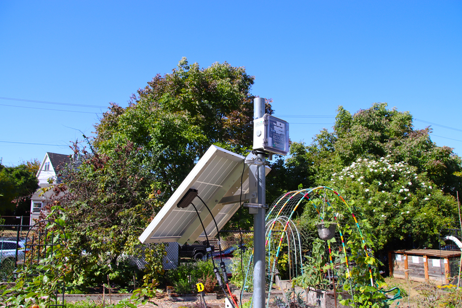 A low-cost in-house air quality monitoring device (called a SensWA) installed near a community garden.